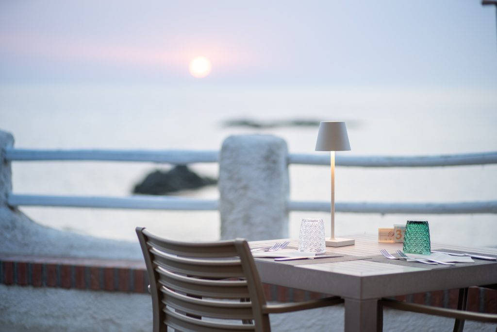Tavolo sulla terrazza del Ristomare al tramonto, con vista sul mare