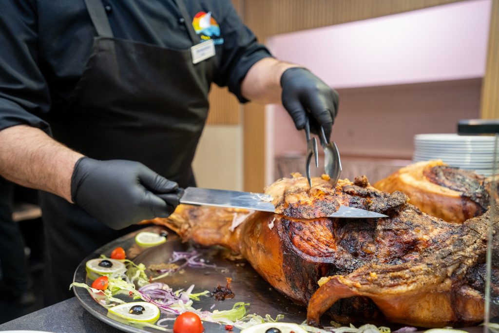 Lo chef taglia il maialino arrosto al buffet del Ristorante Roller Club