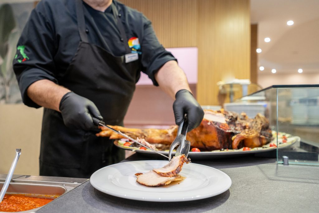 Lo chef serve una porzione di arrosto al buffet del Ristorante Roller Club