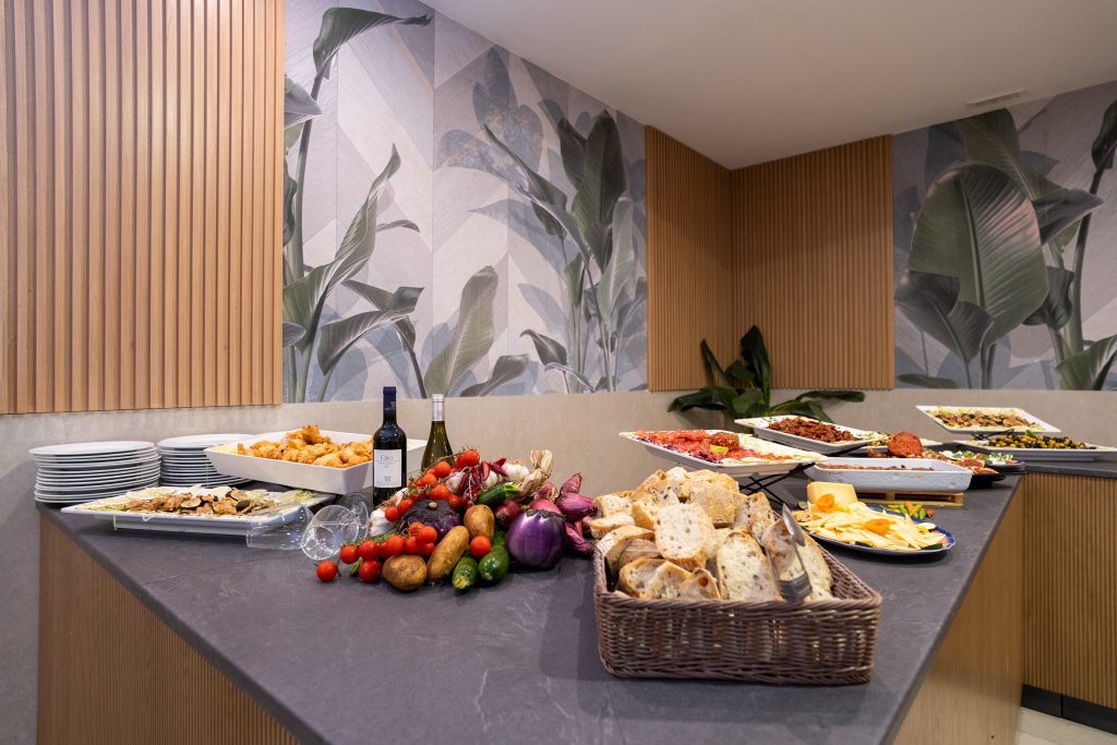 Banco del buffet con antipasti, pane e verdure nella sala ristrutturata